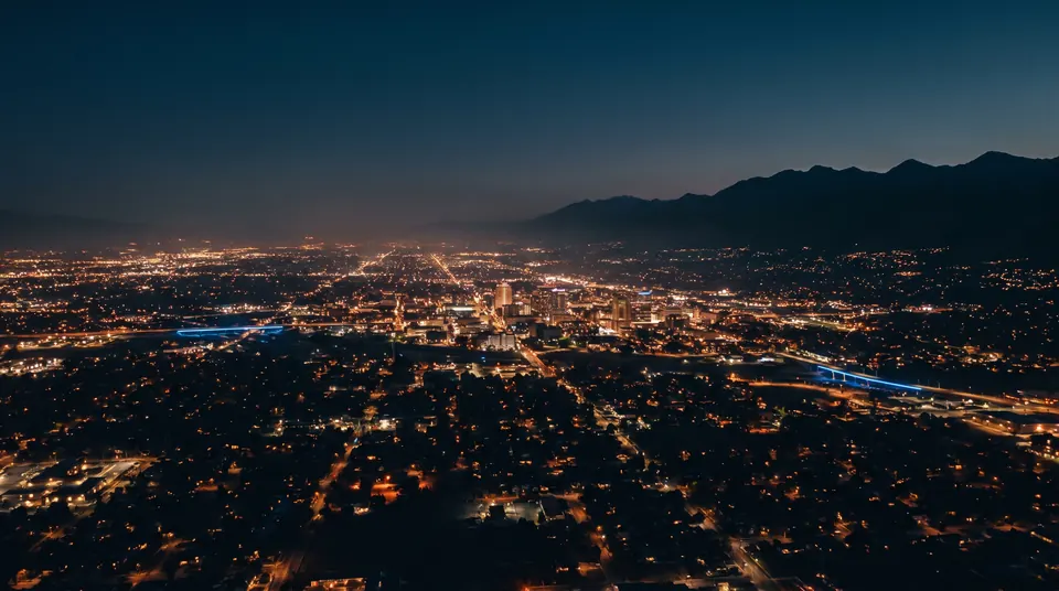Aerial view of the Salt Lake City valley at blue hour with thousands of lights and the Wasatch mountains behind